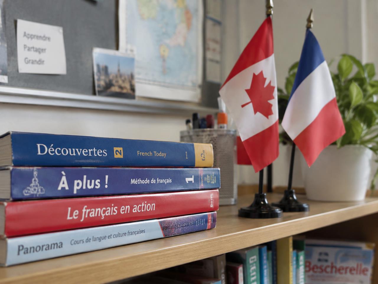 French textbooks beside Canadian and French flags on a classroom shelf